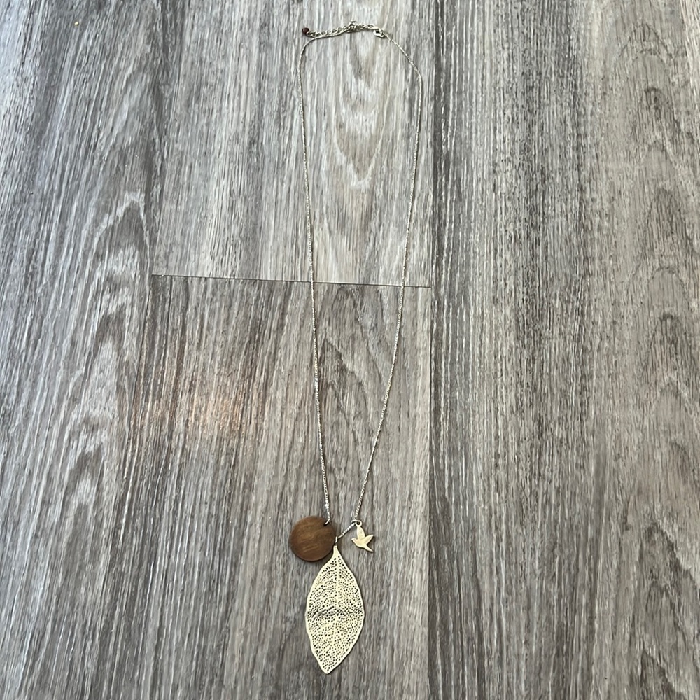 Silver necklace with silver leaf, silver bird and wood circle